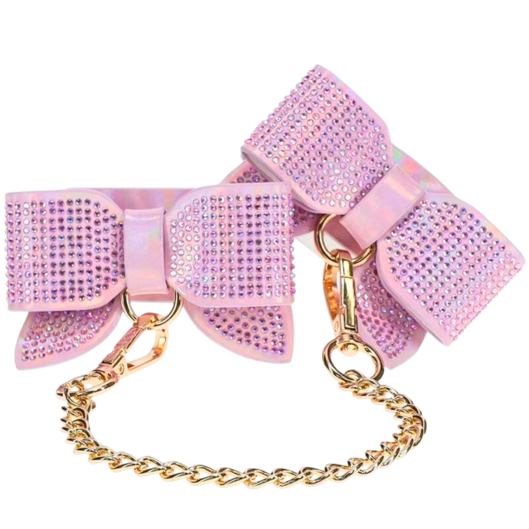 Adjustable handcuffs with rhinestone bows and a gold chain leash, available in black, pink, and blue for stylish and playful BDSM use.