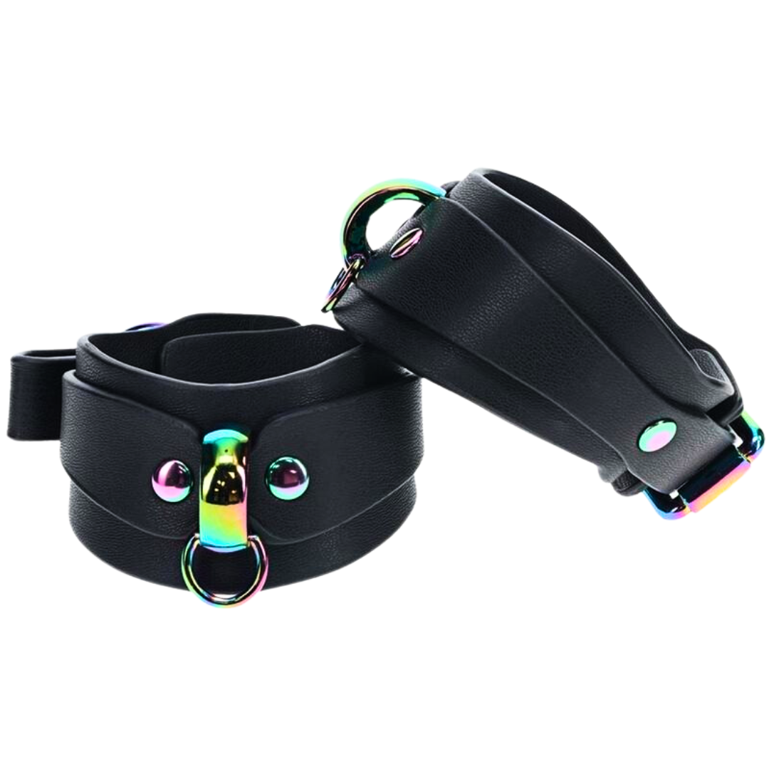 Black bonded leather handcuffs with iridescent hardware and a rainbow chain, designed for stylish BDSM restraint.