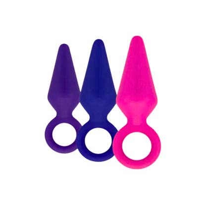 The Candy Rimmer Small Butt Plug shown in three vibrant colors—purple, blue, and pink—with a looped handle for easy retrieval.