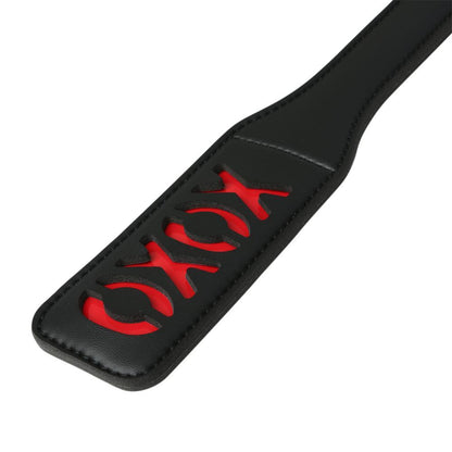 Black vinyl paddle with a red XOXO cutout design, perfect for leaving playful impressions during impact play.