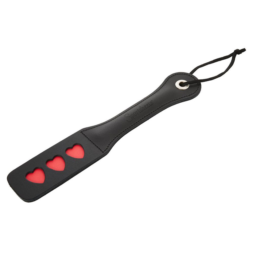 Vegan leather spanking paddle with heart-shaped impressions and a split surface for loud, playful impact.