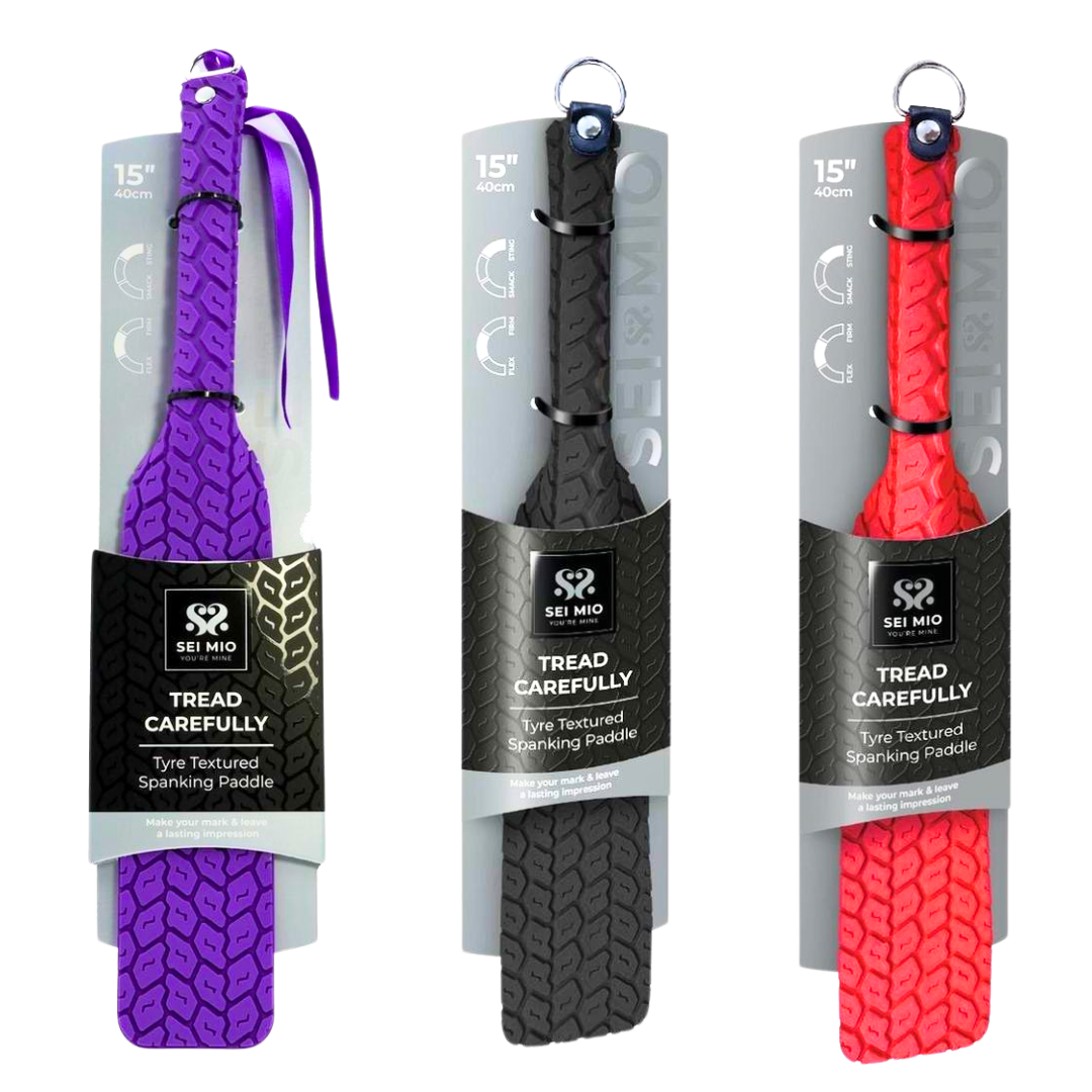 Double-sided spanking paddle with sleek smooth and tyre-textured surfaces, available in Black, Purple, and Red, featuring vegan materials and stylish design.

