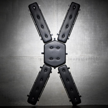 Wall-mounted St. Andrew's Cross with plush PVC padding, multiple attachment points, and compact design. Keywords: wall-mounted St. Andrew's Cross, space-saving BDSM cross, padded St. Andrew's Cross, wall-mounted kink furniture, PVC leather BDSM cross, compact BDSM cross, bondage cross with attachment points, discreet BDSM furniture, St. Andrew's Cross for small spaces, durable BDSM cross.