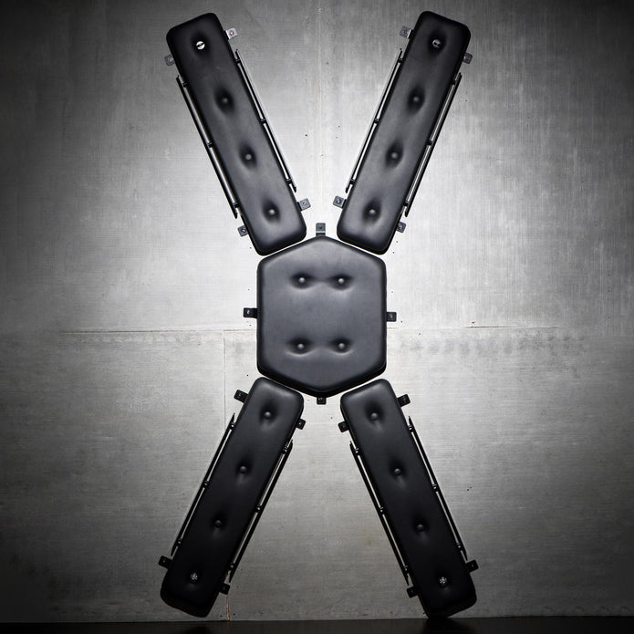 Wall-mounted St. Andrew's Cross with plush PVC padding, multiple attachment points, and compact design. Keywords: wall-mounted St. Andrew's Cross, space-saving BDSM cross, padded St. Andrew's Cross, wall-mounted kink furniture, PVC leather BDSM cross, compact BDSM cross, bondage cross with attachment points, discreet BDSM furniture, St. Andrew's Cross for small spaces, durable BDSM cross.