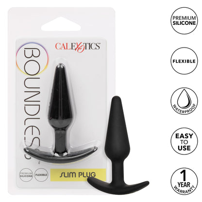 The image shows the Boundless® Slim Plug by CalExotics, packaged in a clear blister pack. The plug has a sleek, black, tapered design with a flared, easy-pull base for safe and comfortable use. Key features highlighted on the packaging include "Premium Silicone," "Flexible," "Waterproof," "Easy to Use," and a "1 Year Warranty." The plug is made from body-safe, flexible silicone, ideal for both beginners and experienced users looking for streamlined pleasure and easy handling.