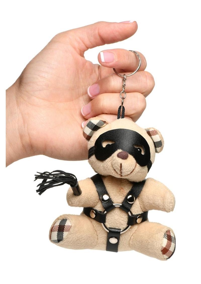 Mini bondage bear with harness, flogger, and removable eye mask for kinky gifting or accessories.

bondage bear keychain, BDSM novelty gift, bondage bear accessory, kinky keychain gift, leather harness bear, mini BDSM bear, bondage-themed gifts, faux leather keychain bear, bondage novelty toys, BDSM flagging accessory