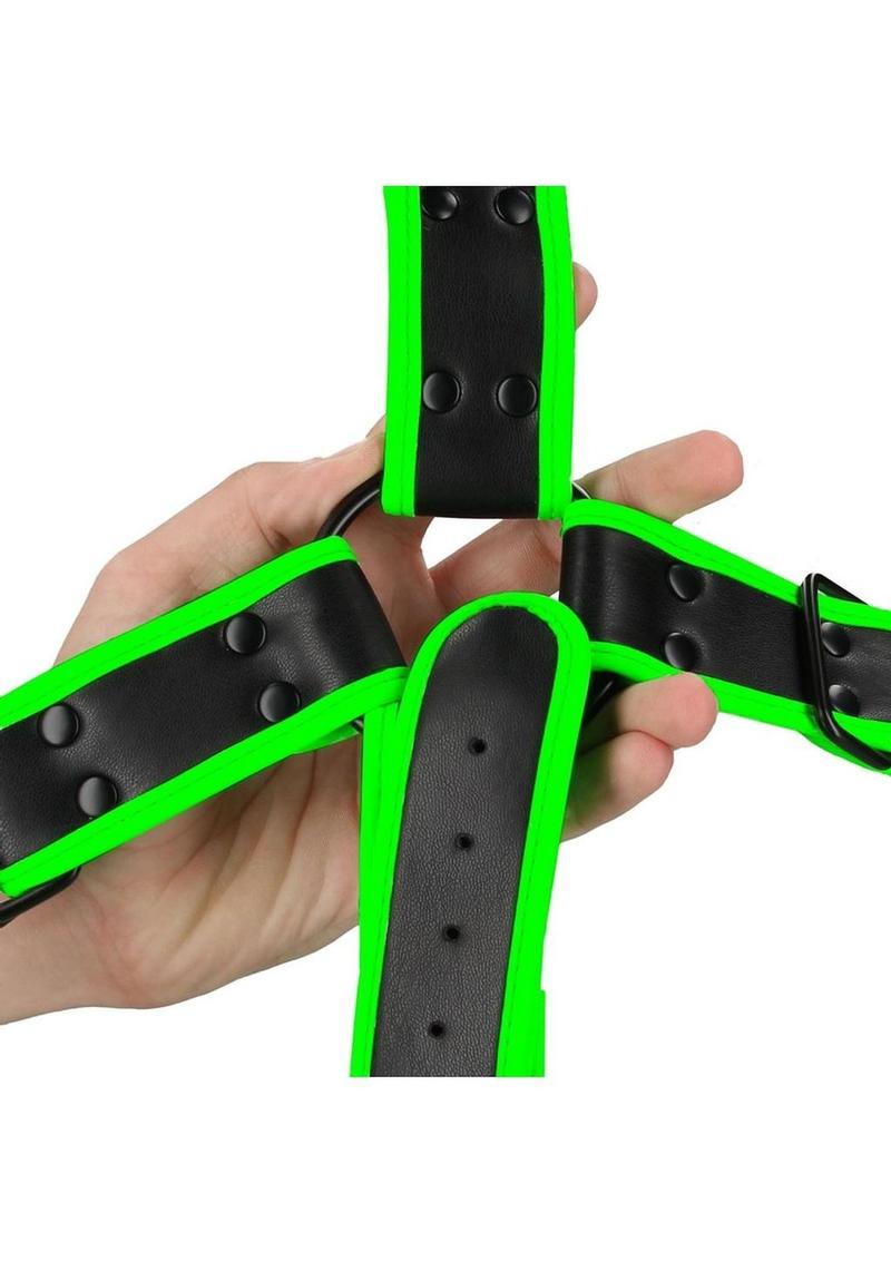 Glow-in-the-dark cross harness with adjustable straps and fluorescent green detailing. Keywords: Ouch Glow in the Dark Cross Harness, glow-in-the-dark harness, fluorescent green harness, adjustable bondage harness, BDSM glow gear, glow-in-the-dark rave harness, men’s bondage gear, cross-style harness, neon kink accessories, glow BDSM harness