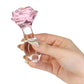 Pink rose-shaped glass anal plug with a tapered stem and elegant base for temperature play and luxurious anal stimulation. Keywords: glass anal plug, pink rose anal plug, luxurious anal toy, borosilicate glass plug, elegant anal stimulation, temperature play toy, beginner-friendly anal plug, body-safe anal plug, easy-to-clean glass toy, PowerBullet anal plug.