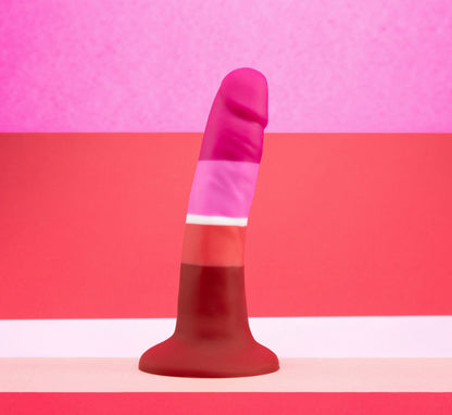 Lesbian pride-colored silicone dildo with a petite design, straight shaft, and suction base, made from smooth Purio™ silicone. Keywords: lesbian pride dildo, Avant dildo, petite dildo, beginner-friendly dildo, suction cup dildo, harness-compatible dildo, body-safe silicone dildo, colorful pride dildo, Purio silicone, artisan-crafted dildo.
